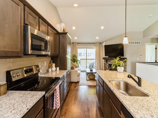 1102 NE 15th Ln, Ankeny, IA 50021 - kitchen featuring appliances with stainless steel finishes, dark wood-style flooring, backsplash, dark brown cabinets, and recessed lighting