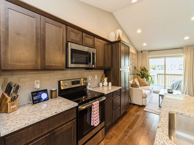 1102 NE 15th Ln, Ankeny, IA 50021 - kitchen featuring stainless steel appliances, lofted ceiling, dark wood-style floors, decorative backsplash, and dark brown cabinets