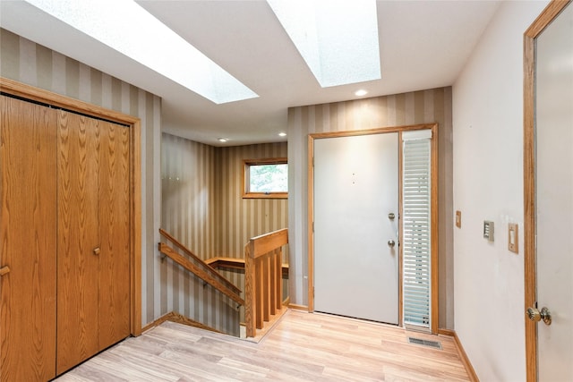 4922 Cedar Dr, West Des Moines, IA 50266 - foyer entrance featuring a skylight, light wood finished floors, wallpapered walls, and recessed lighting