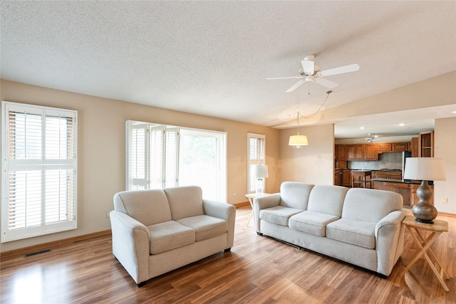 4922 Cedar Dr, West Des Moines, IA 50266 - living area with wood finished floors, ceiling fan, healthy amount of natural light, a textured ceiling, and vaulted ceiling