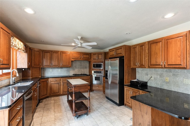 4922 Cedar Dr, West Des Moines, IA 50266 - kitchen featuring stainless steel appliances, brown cabinetry, decorative backsplash, a ceiling fan, and recessed lighting