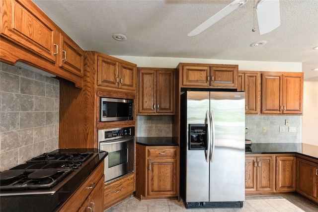 4922 Cedar Dr, West Des Moines, IA 50266 - kitchen featuring stainless steel appliances, backsplash, brown cabinetry, a textured ceiling, and recessed lighting