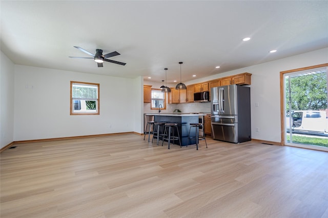 609 17th St, West Des Moines, IA 50265 - kitchen with stainless steel refrigerator with ice dispenser, a kitchen breakfast bar, recessed lighting, light wood-style floors, and ceiling fan