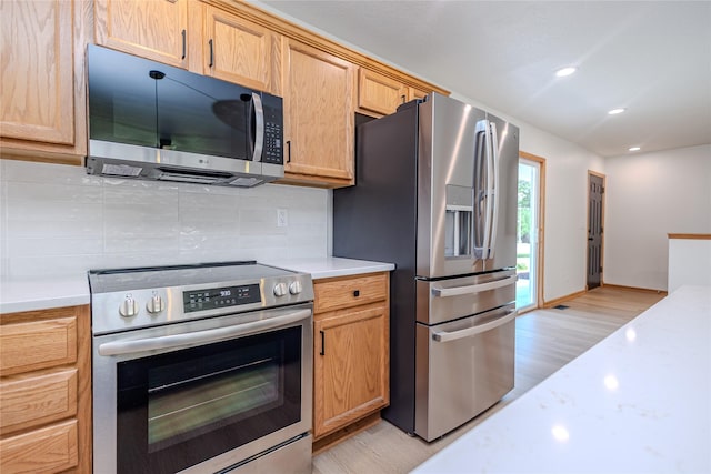 609 17th St, West Des Moines, IA 50265 - kitchen featuring stainless steel appliances, light wood-style floors, light countertops, tasteful backsplash, and recessed lighting