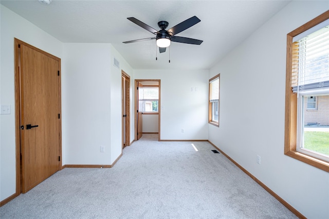 609 17th St, West Des Moines, IA 50265 - unfurnished bedroom with multiple windows, light colored carpet, and ceiling fan