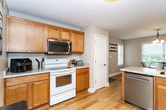 2732 Northridge Ln, Ames, IA 50010 - kitchen with stainless steel appliances, light wood-type flooring, light countertops, pendant lighting, and brown cabinetry