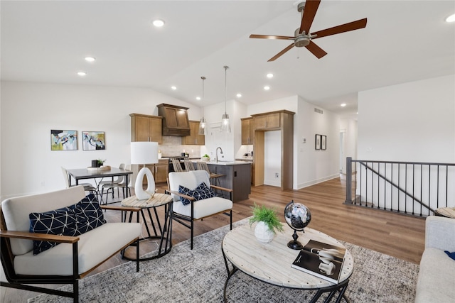 150 NW Hidden Knl, Waukee, IA 50263 - living area with vaulted ceiling, a ceiling fan, light wood finished floors, and recessed lighting