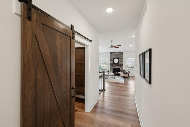 150 NW Hidden Knl, Waukee, IA 50263 - corridor featuring a barn door, light wood-style floors, and recessed lighting