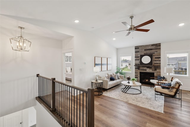 150 NW Hidden Knl, Waukee, IA 50263 - living area featuring healthy amount of natural light, wood finished floors, vaulted ceiling, a fireplace, and a ceiling fan