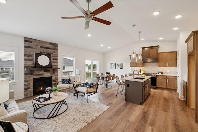 150 NW Hidden Knl, Waukee, IA 50263 - kitchen with open floor plan, stainless steel stove, lofted ceiling, a ceiling fan, and under cabinet range hood