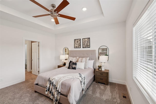 150 NW Hidden Knl, Waukee, IA 50263 - carpeted bedroom featuring multiple windows, recessed lighting, a tray ceiling, and ceiling fan