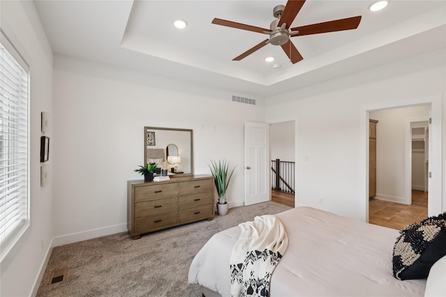 150 NW Hidden Knl, Waukee, IA 50263 - bedroom featuring multiple windows, recessed lighting, a tray ceiling, and ceiling fan