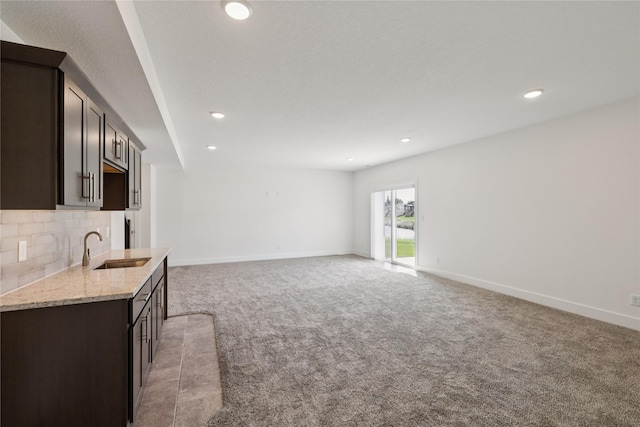 150 NW Hidden Knl, Waukee, IA 50263 - unfurnished living room featuring light carpet, recessed lighting, and bar with sink
