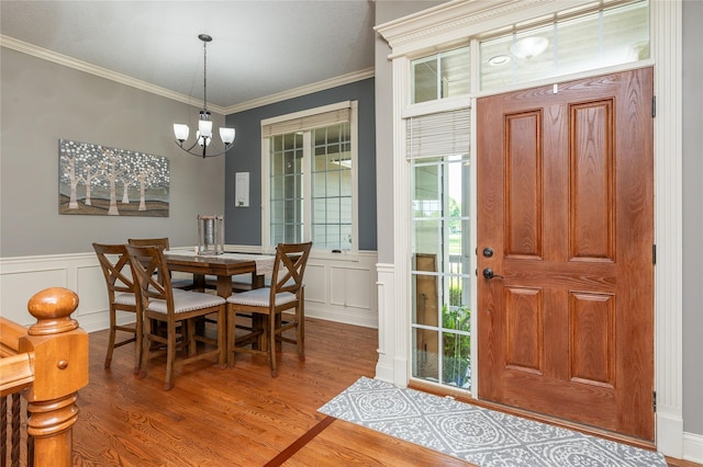 6725 NW 93rd St, Johnston, IA 50131 - dining room with a chandelier, ornamental molding, wood finished floors, wainscoting, and a decorative wall