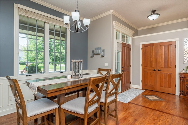 6725 NW 93rd St, Johnston, IA 50131 - dining space featuring wood finished floors, a chandelier, and crown molding