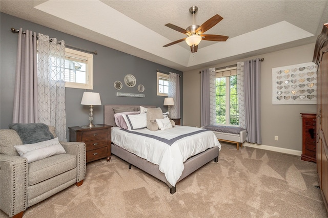 6725 NW 93rd St, Johnston, IA 50131 - bedroom with a tray ceiling, light colored carpet, a textured ceiling, and a ceiling fan