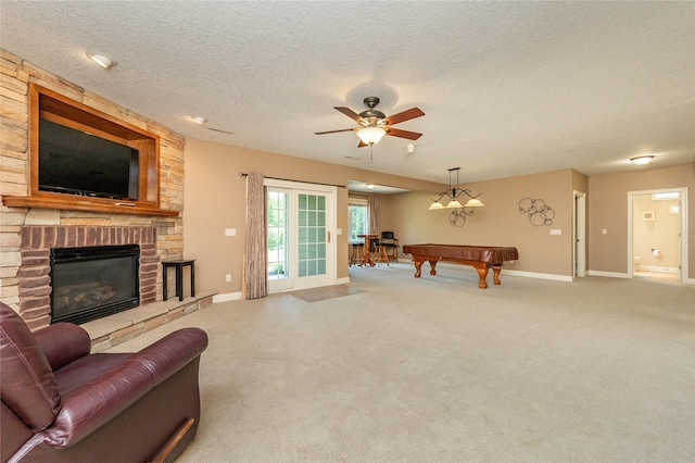 6725 NW 93rd St, Johnston, IA 50131 - living room with a stone fireplace, pool table, carpet floors, a ceiling fan, and a textured ceiling