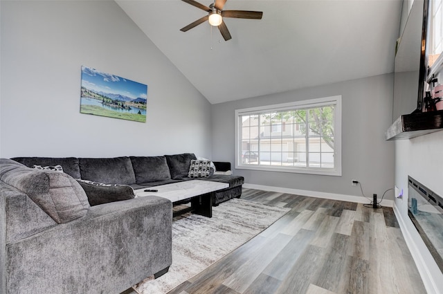 5462 Longview Ct Unit 1, Johnston, IA 50131 - living room featuring wood finished floors, lofted ceiling, a ceiling fan, and a glass covered fireplace