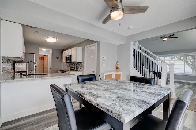 5462 Longview Ct Unit 1, Johnston, IA 50131 - dining room with wood finished floors, ceiling fan, and stairs