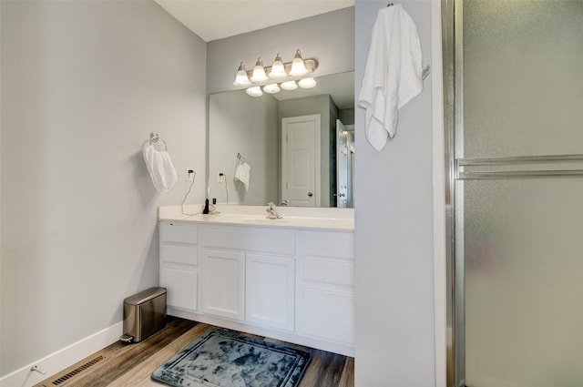 5462 Longview Ct Unit 1, Johnston, IA 50131 - full bath featuring wood finished floors, vanity, and a shower with shower door
