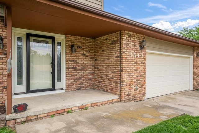 1543 S 16th Ave W, Newton, IA 50208 - view of exterior entry featuring brick siding, driveway, and a porch