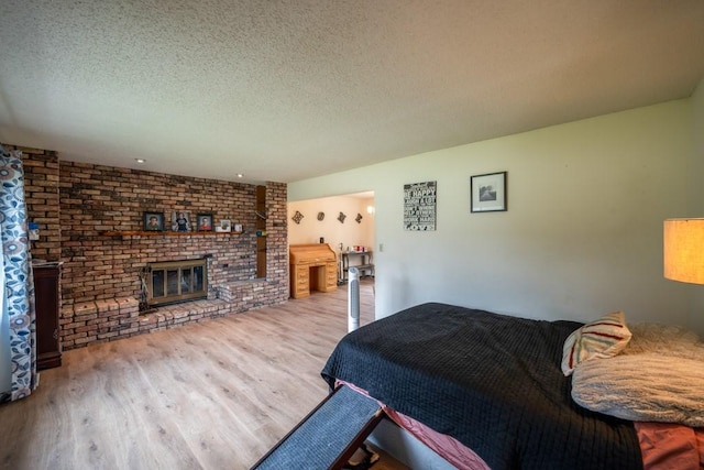 1543 S 16th Ave W, Newton, IA 50208 - bedroom featuring wood finished floors, a textured ceiling, and a fireplace