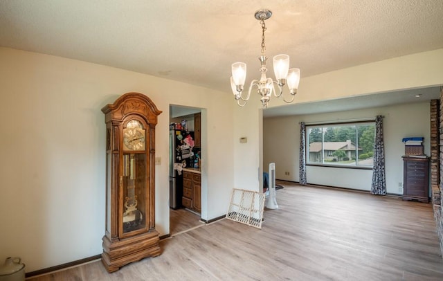 1543 S 16th Ave W, Newton, IA 50208 - unfurnished room with light wood-type flooring, a chandelier, and a textured ceiling