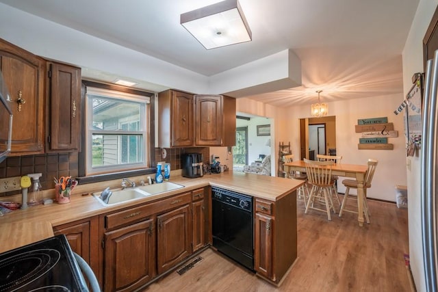 1543 S 16th Ave W, Newton, IA 50208 - kitchen featuring black dishwasher, light countertops, tasteful backsplash, a peninsula, and plenty of natural light