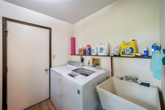1543 S 16th Ave W, Newton, IA 50208 - laundry area with washer and clothes dryer, a textured ceiling, and light wood-style flooring