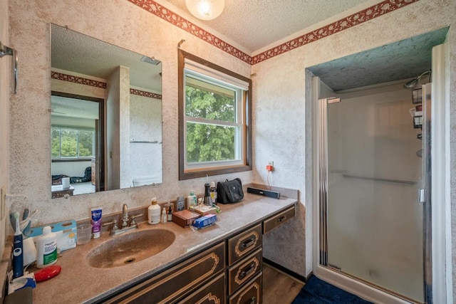 1543 S 16th Ave W, Newton, IA 50208 - bathroom featuring vanity, a textured ceiling, a stall shower, wood finished floors, and wallpapered walls