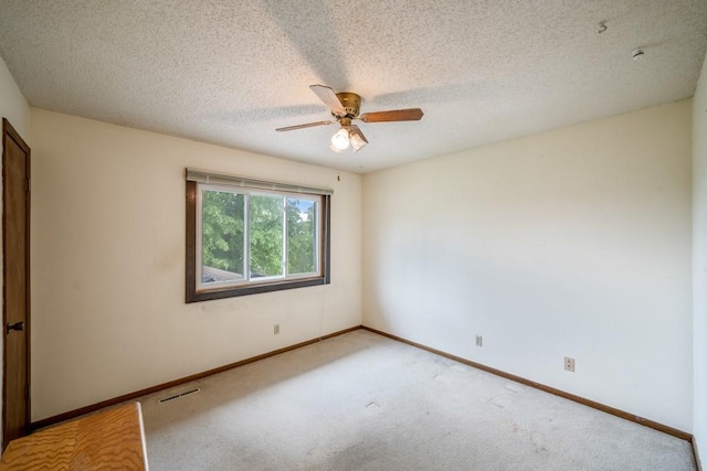 1543 S 16th Ave W, Newton, IA 50208 - spare room with a ceiling fan, light colored carpet, and a textured ceiling
