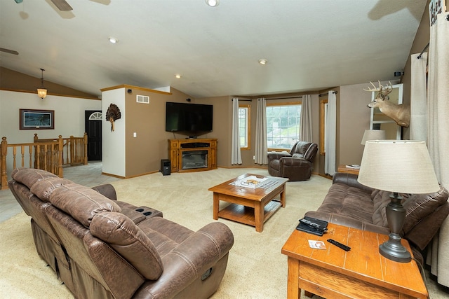 2626 SE 72nd St, Runnells, IA 50237 - living room featuring lofted ceiling, carpet floors, a glass covered fireplace, and a ceiling fan