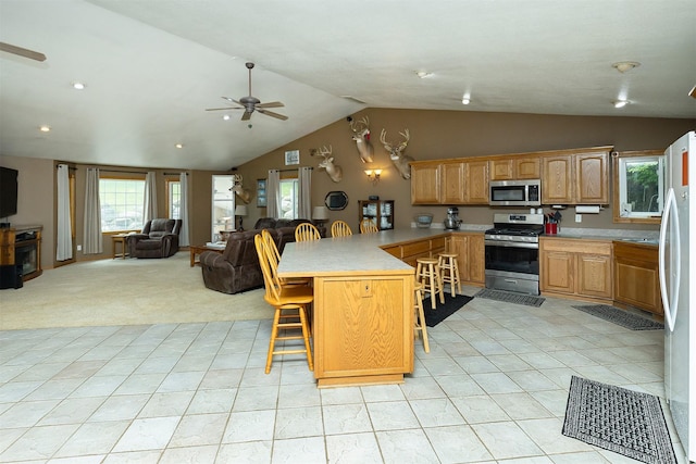 2626 SE 72nd St, Runnells, IA 50237 - kitchen with appliances with stainless steel finishes, a peninsula, open floor plan, ceiling fan, and a breakfast bar area