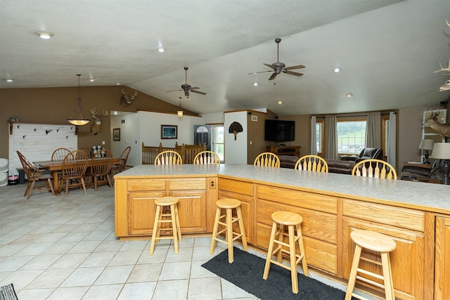 2626 SE 72nd St, Runnells, IA 50237 - kitchen featuring a ceiling fan, lofted ceiling, open floor plan, a breakfast bar, and light countertops