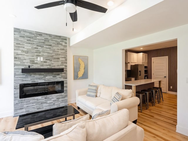 1010 Frederick Ave, Des Moines, IA 50315 - living room featuring a ceiling fan, light wood finished floors, and a tiled fireplace