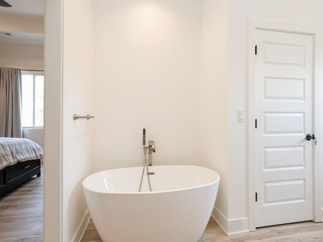 1010 Frederick Ave, Des Moines, IA 50315 - full bath featuring a freestanding bath, wood finished floors, and connected bathroom