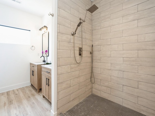 1010 Frederick Ave, Des Moines, IA 50315 - bathroom with tiled shower, vanity, and wood finished floors