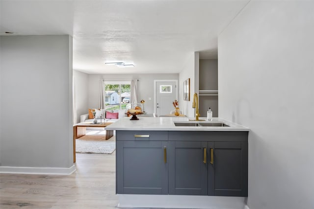 4127 E Seneca Ave, Des Moines, IA 50317 - kitchen featuring light wood-type flooring, a peninsula, light countertops, and gray cabinets