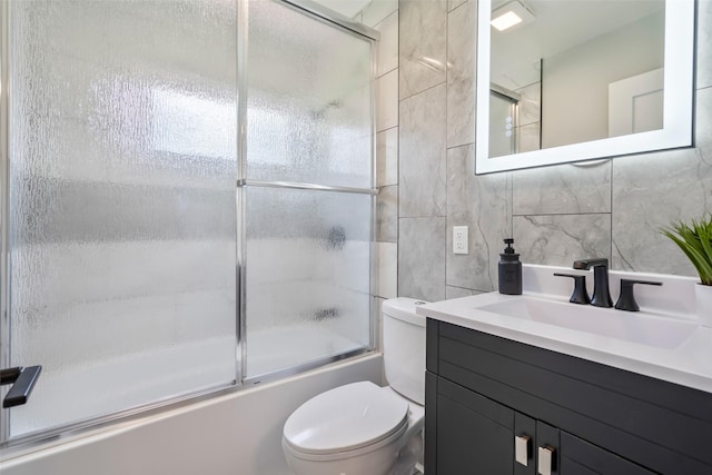 4127 E Seneca Ave, Des Moines, IA 50317 - bathroom with combined bath / shower with glass door, vanity, tile walls, and decorative backsplash