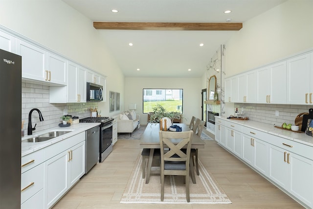 2004 Ammann Dr, Adel, IA 50003 - kitchen with appliances with stainless steel finishes, tasteful backsplash, white cabinets, beamed ceiling, and high vaulted ceiling