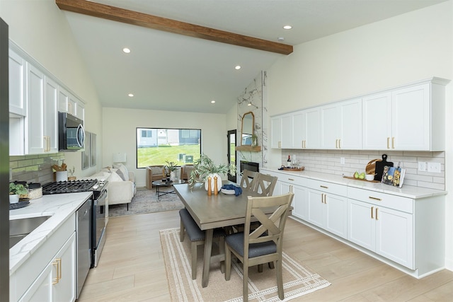 2004 Ammann Dr, Adel, IA 50003 - kitchen with appliances with stainless steel finishes, high vaulted ceiling, backsplash, beamed ceiling, and white cabinetry