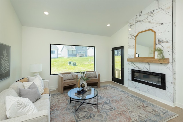 2004 Ammann Dr, Adel, IA 50003 - living area featuring wood finished floors, a fireplace, vaulted ceiling, and recessed lighting