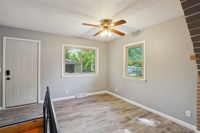 2515 Glenbrook Dr, Des Moines, IA 50316 - spare room featuring healthy amount of natural light, ceiling fan, wood finished floors, and a textured ceiling