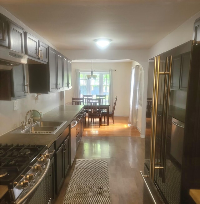 707 E 27th St S, Newton, IA 50208 - kitchen featuring arched walkways, wood finished floors, decorative light fixtures, and stainless steel appliances