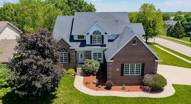 6511 NW 93rd St, Johnston, IA 50131 - traditional-style home featuring brick siding, a front yard, and a shingled roof