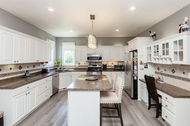 6511 NW 93rd St, Johnston, IA 50131 - kitchen with stainless steel appliances, decorative backsplash, a kitchen island, white cabinets, and recessed lighting