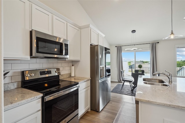 2814 Long Ave, Van Meter, IA 50261 - kitchen featuring stainless steel appliances, white cabinets, light wood finished floors, tasteful backsplash, and pendant lighting