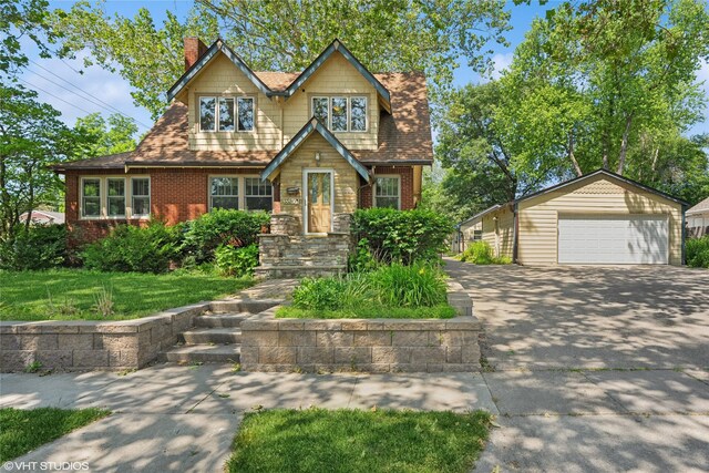 3320 SW 12th St, Des Moines, IA 50315 - view of front of home with a detached garage, an outdoor structure, a chimney, and brick siding