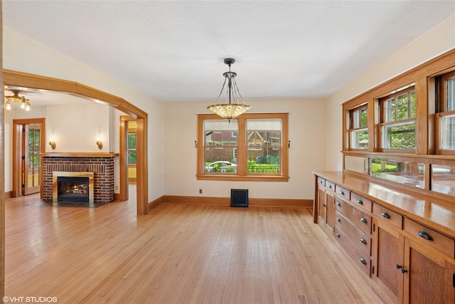 3320 SW 12th St, Des Moines, IA 50315 - dining area featuring a chandelier, light wood-type flooring, and a brick fireplace
