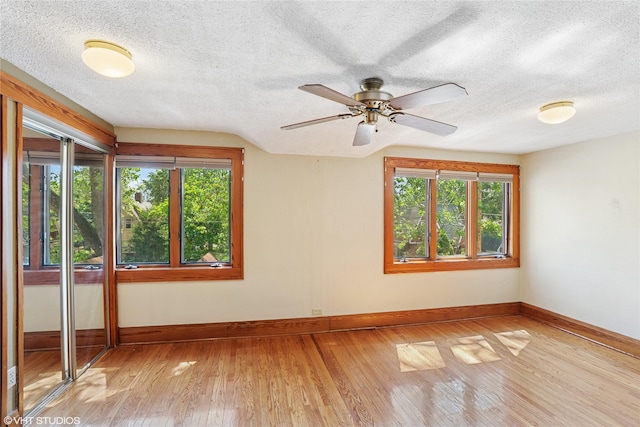 3320 SW 12th St, Des Moines, IA 50315 - empty room featuring light wood-type flooring, healthy amount of natural light, a textured ceiling, and a ceiling fan